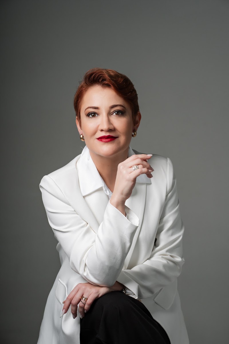 Dra. Tássia Moreira de blazer branco, retrato de meio corpo